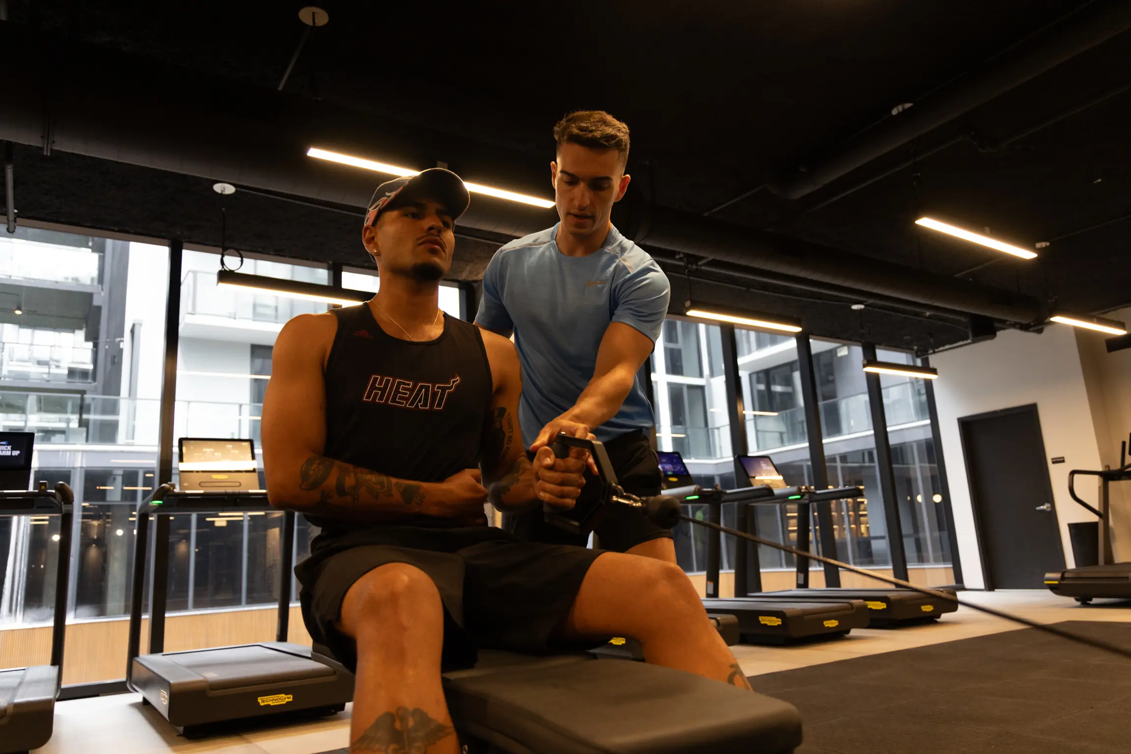 Personal trainer coaching a client through a seated cable row at a private Miami gym